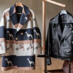 A stylish coat hanging on a wooden rack beside a sleek jacket draped over a chair